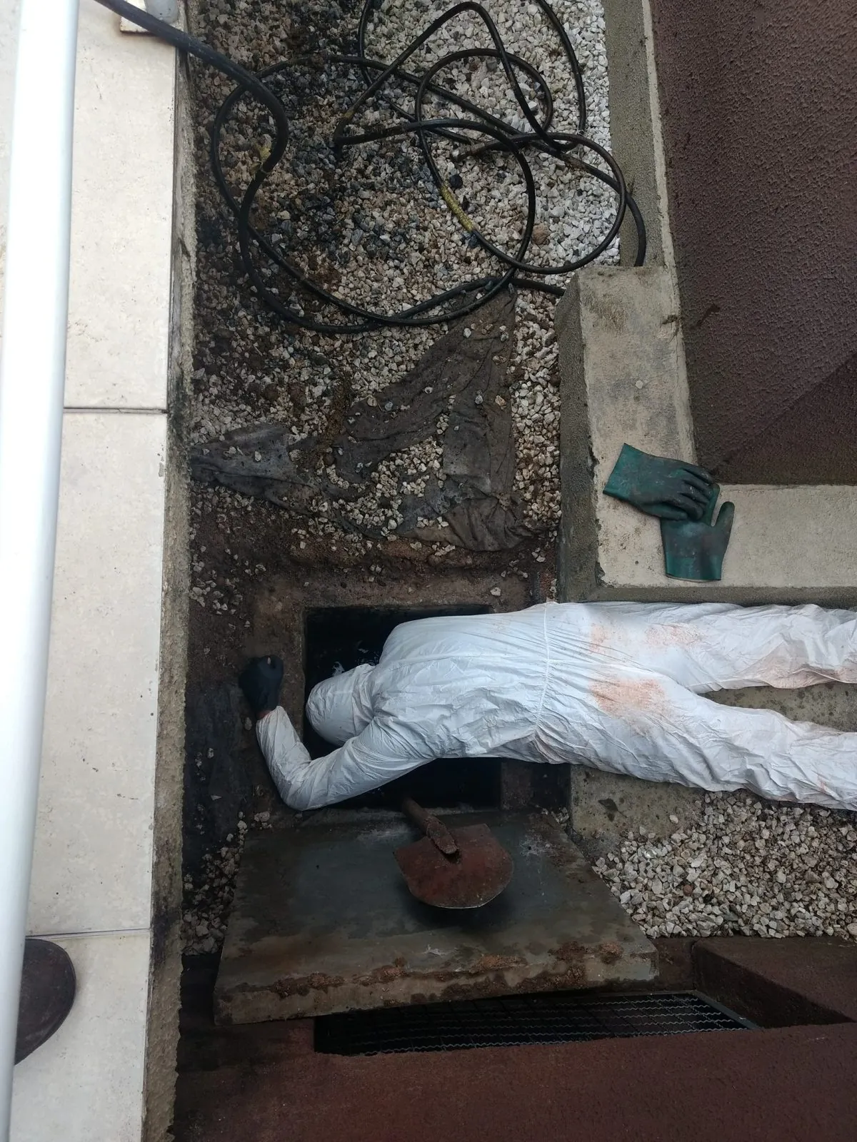 Técnico trabalhando dentro de uma caixa de inspeção de esgoto